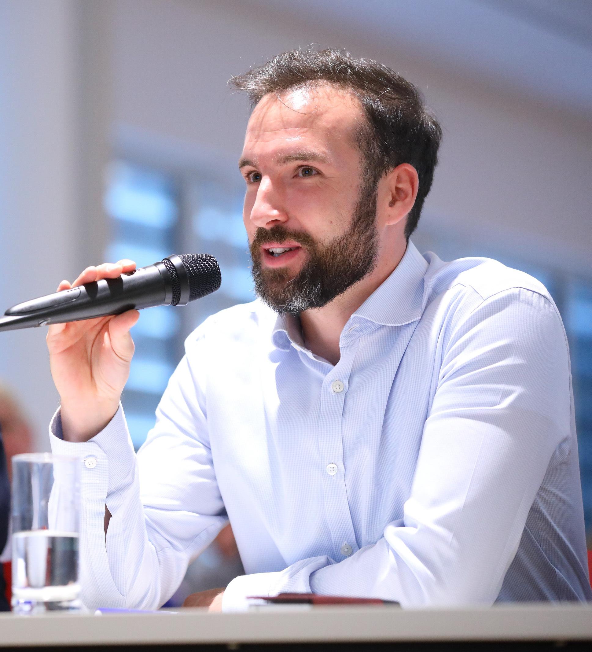 Stefan Kermer speaking on an EU ETS panel, microphone in hand